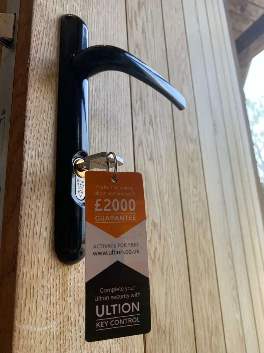 Ultion three star cylinder and black lever handle fitted to a light oak timber door