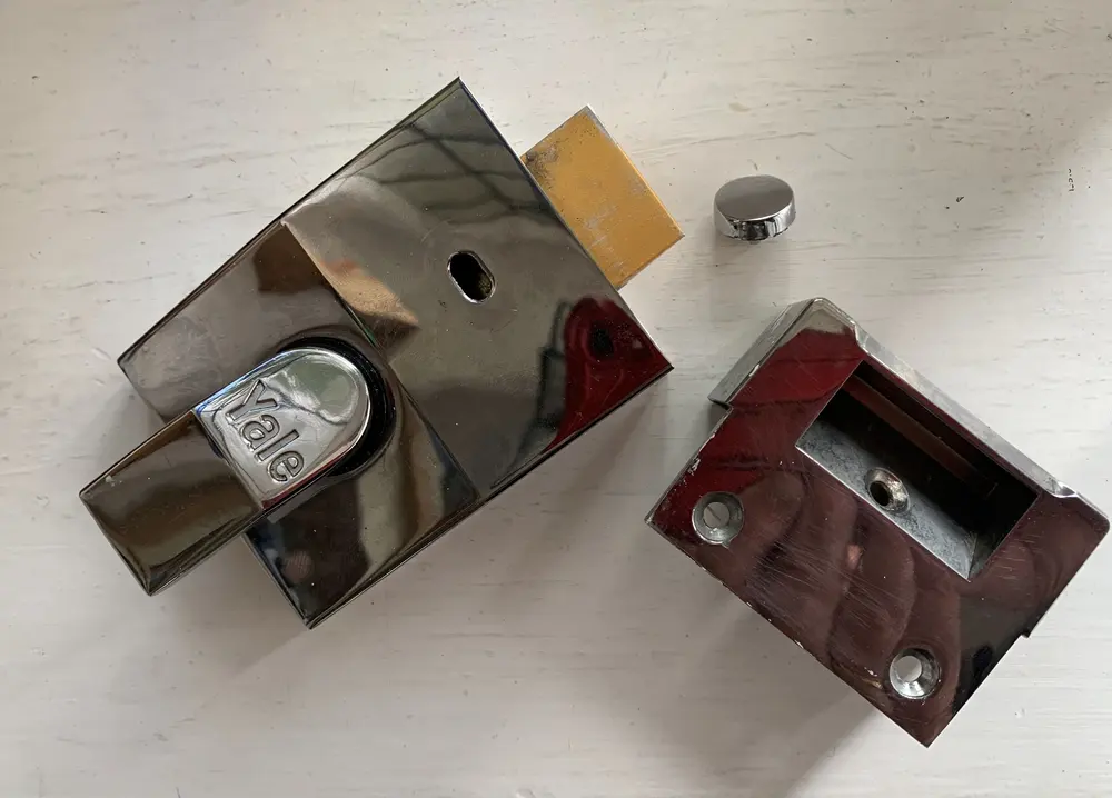 New chrome Yale night latch and matching keep laid out before fitting