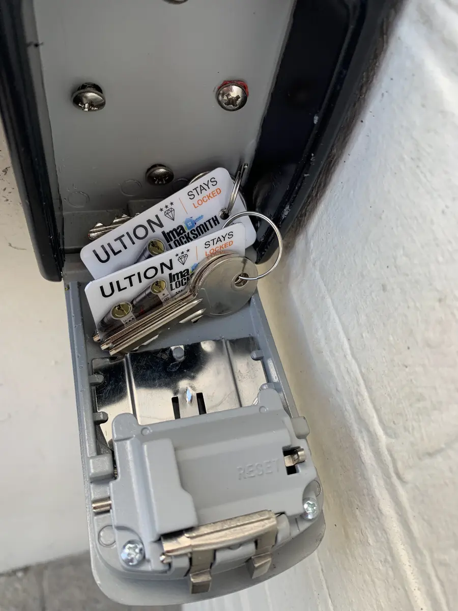 Open wall-mounted key safe holding spare keys on Ultion and Ima Locksmith branded cards