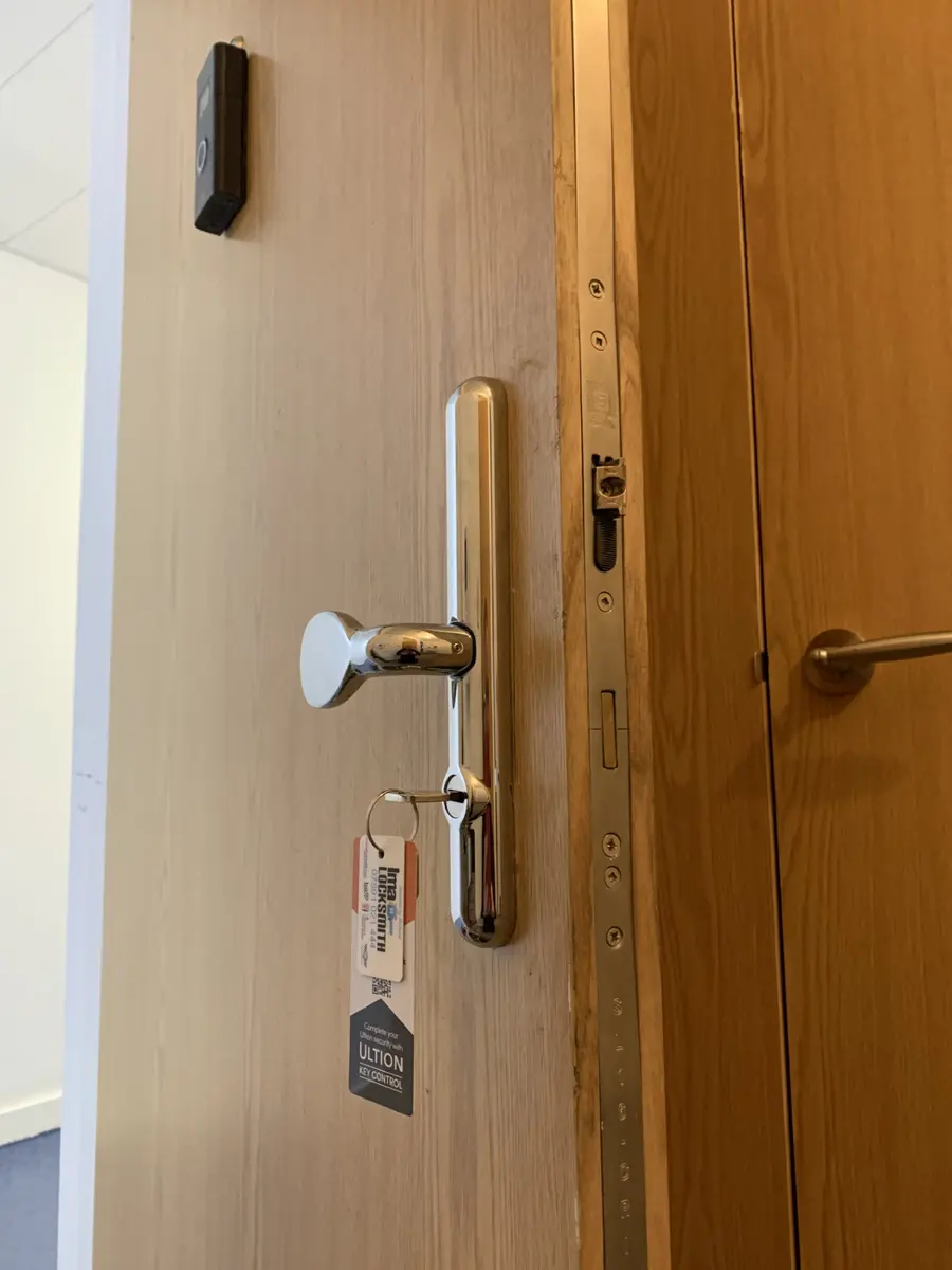 Chrome multipoint handle and new cylinder on an oak office door, Ima Locksmith and Ultion tags on the key