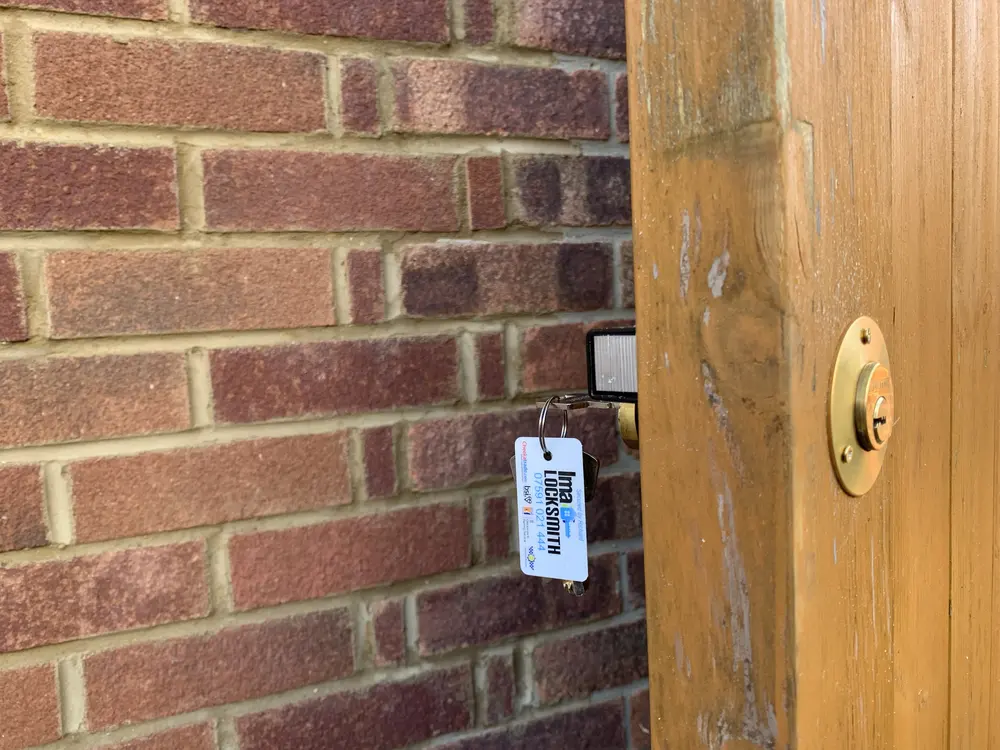 Brass rim cylinder gate lock fitted to a timber side gate, Ima Locksmith tag on the keys