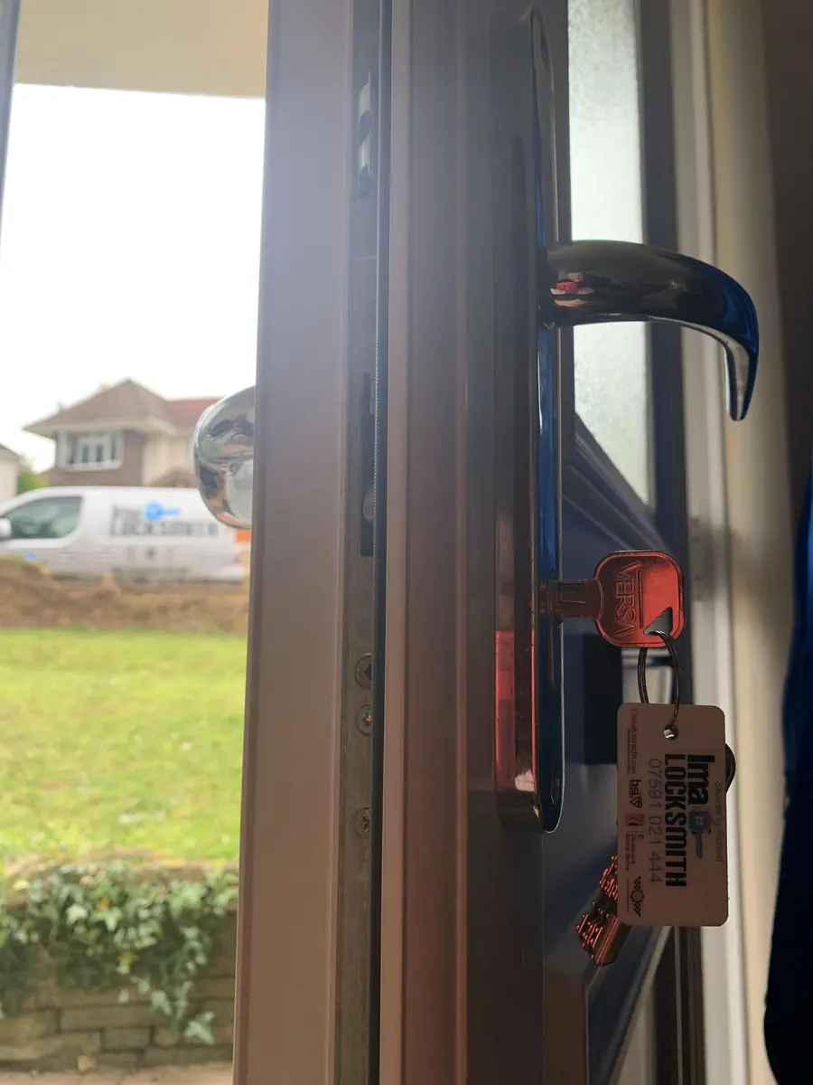 Chrome lever handle and new euro cylinder on a blue door, red Versa key with Ima Locksmith tag