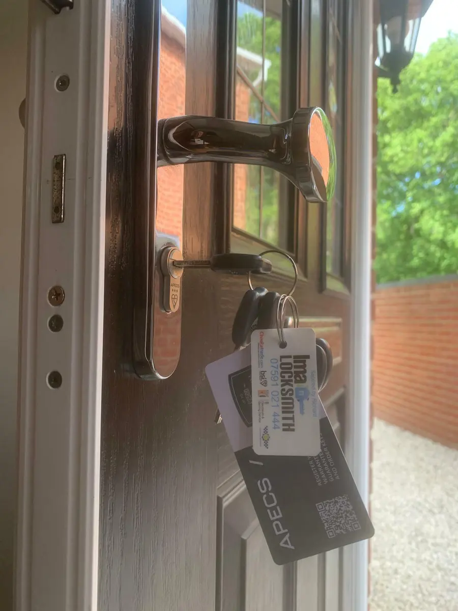 APECS three star anti-snap cylinder and chrome pad handle on a black composite door, Ima Locksmith tag on keys