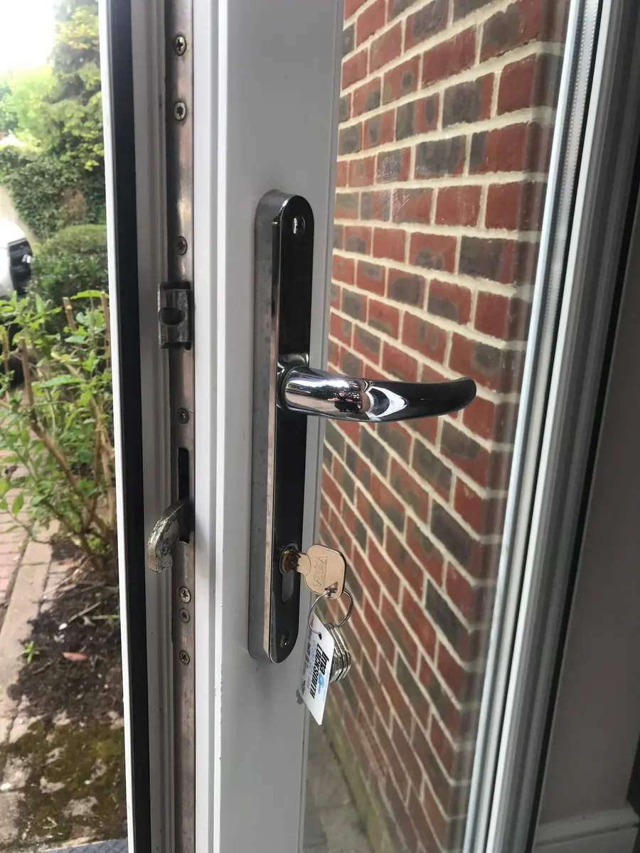 White uPVC door with multipoint hook bolt extended, chrome lever handle and Versa key with Ima Locksmith tag