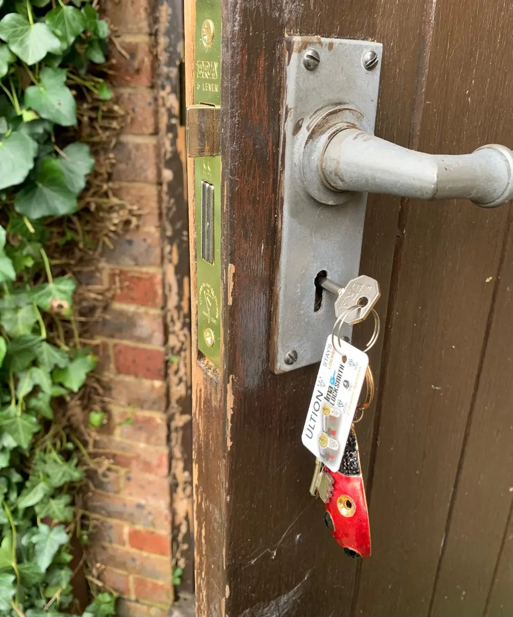 Brass ERA five lever mortice sashlock fitted to a weathered timber door with key tags