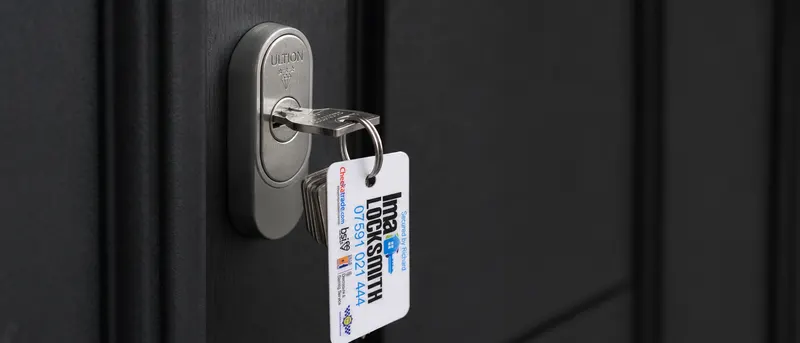 IMA Locksmith branded keyring hanging from a key in an Ultion escutcheon